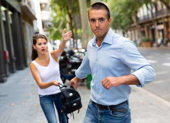 Bandit man is stole the handbag from emotional female on the street