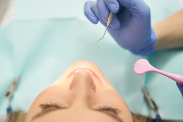 Dentist examining woman teeth with dental tools