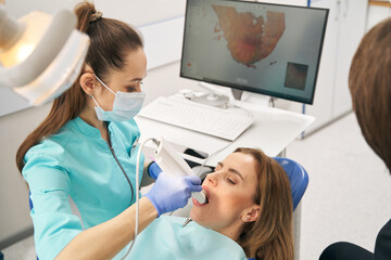 Dentist scanning woman teeth with dental intraoral 3D scanner - obrazy, fototapety, plakaty