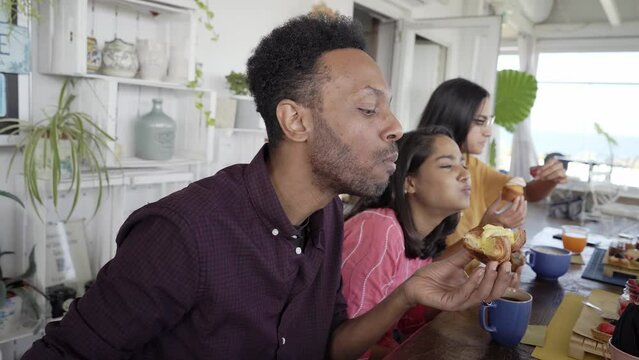 African American man having breakfast with friends. Afro guy eating cake with her girlfriend