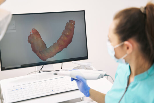 Dentist analyzing 3D scan of patient teeth in clinic