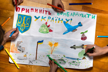 Children drawing big picture about war in Ukraine with call stop bombing their country
