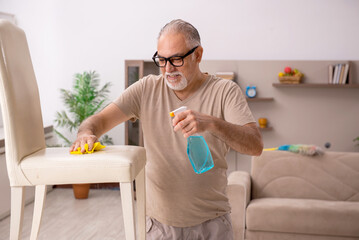 Old man doing housework at home