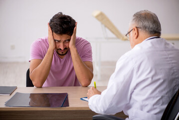 Young male patient visiting old male doctor