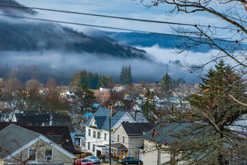 Fototapeta premium Bradford PA mountain USA town with morning fog rising above the mountains, landscape nature composed with classic building architecture.
