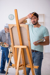 Two male painters enjoying painting at home