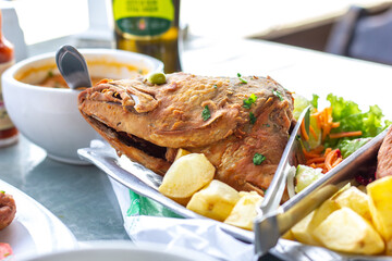 fried fish dish with browned potatoes and shrimp pirão (brazilian sauce)