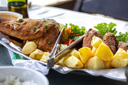 fried fish dish with browned potatoes and shrimp pir&atilde;o (brazilian sauce)