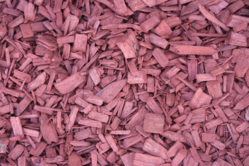 A pile of red wood chip mulch in a garden