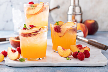 Refreshing summer cocktail with peach and raspberry