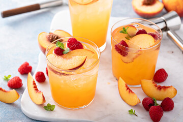 Refreshing summer cocktail with peach and raspberry