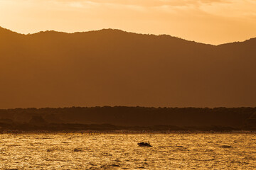 Late afternoon photo on the beach. Clouds over the mountains in the background, the beach and a...