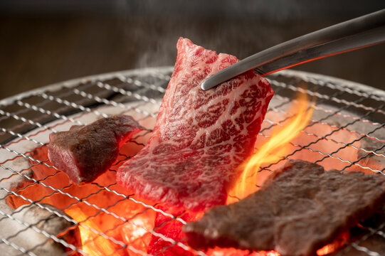 赤身の肉を炭火の七輪で焼く