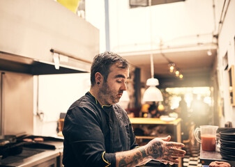 He is in his element. Shot of a focused chef preparing a dish in the kitchen of a restaurant.