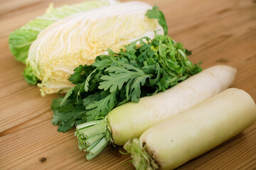 Fresh Daikon radish, Kikuna leaves and Hakusai / Napa cabbage sitting on wooden table