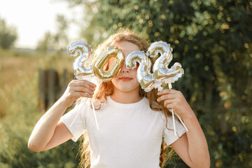 Cute girl in a white t-shirt is holding balloons