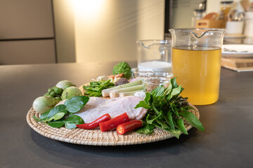 The ingredients, including chicken wings, chilli, kaffir lime leaves and lemongrass, are prepared to be cooked for a famous thai dish, Green Curry.