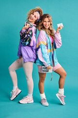 Were out spreading some 80s vibes. Studio shot of two beautiful young women styled in 80s clothing. - obrazy, fototapety, plakaty