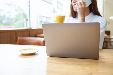 Closeup image of a businesswoman using and talking on mobile phone while working on laptop computer