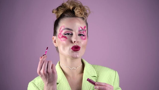 Young, beautiful woman professional make up artist with lipstick marks smile at pink background, beauty girl advertises fashion cosmetic at her video blog, smiling pretty. 4k high quality video