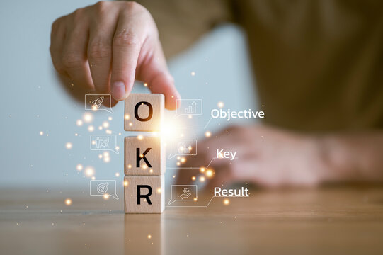 OKR, Objectives, Key, Results, Hand Putting Wooden Cube Blocks With Text OKR. Business Target, Drive Business And Performance. Focus On Goal. Achieve Business Growth By Flexible Management