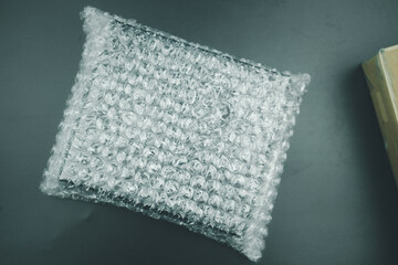 Black cardboard box wrapped in bubble wrap