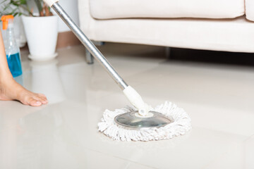 Asian woman washes the floor with a mop and rag indoors, housewife washing floor mopping at home in living room cleaning her home, Professional housekeeping job house cleanup concept