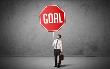 Obraz premium Young business person holding road sign