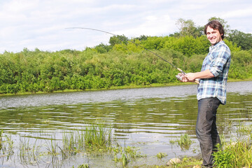 A man with a beard is fishing in the river