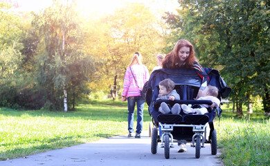 walk women with stroller summer sunlight