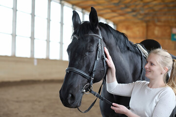 People on a horse training in a wooden arena