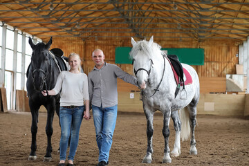 People on a horse training in a wooden arena