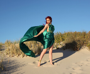 Full length portrait of  red haired woman wearing a  beautiful  long green  silk toga gown....