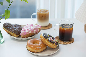 Colorful doughnut with cup of coffee on white table