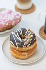 Colorful doughnut with cup of coffee on white table