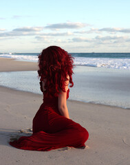 Full length portrait of  redhead woman wearing elegant gown. Standing  pose with gestural hands at...