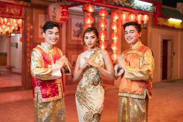 two asian men A young woman wearing traditional Chinese cheongsam holds