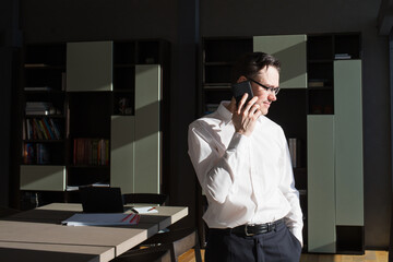 businessman man calls talking on phone against background of workplace in office or at home. white - collar workers