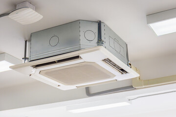 Modern ceiling mounted cassette type air conditioning system in the room