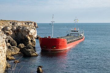 Cargo ship crash, stuck on rocky shore.