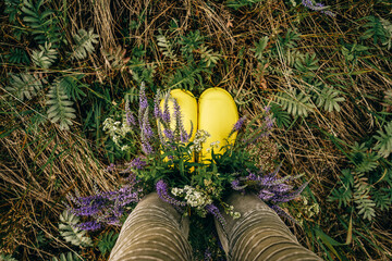 Yellow rubber boots with wildflowers. Top view.