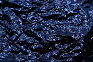 Crumpled very peri or violet foil background. Abstract pattern. Trendy color of the Year 2022.