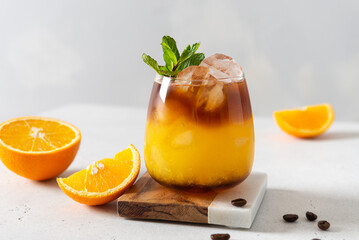 Trendy coffee shop seasonal drink: iced coffee with orange juice and caramel syrup. Bumble coffee...