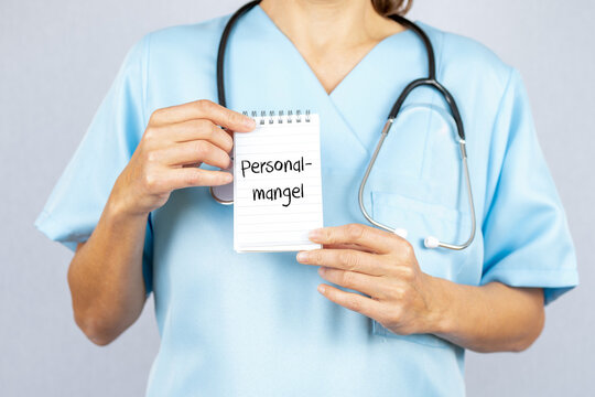 Krankenschwester mit einem Notizblock auf dem Personalmangel steht