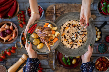A cooked lamp in the copper pot lamb with pilau, small plates, carrots