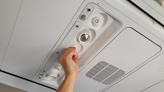 Girl adjusts the air flow in the plane.