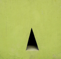 Geometric shape of triangle shadow in green concrete wall