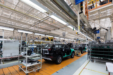 Car bodies are on assembly line. Factory for production of cars. Modern automotive industry. A car being checked before being painted in a high-tech enterprise