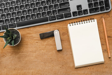 Hardware Wallet for cryptocurrency and keyboard on table with note