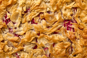 Food background homemade cherry pie from filo dough. Top view. Close up